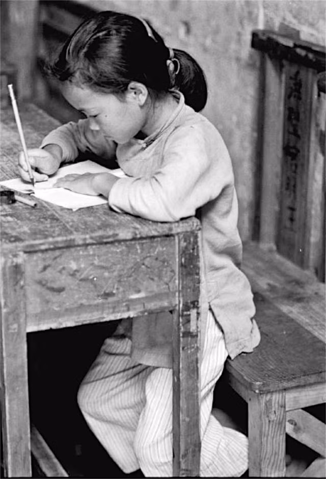 Một em bé say sưa tập viết. Nguồn ảnh: Sina.