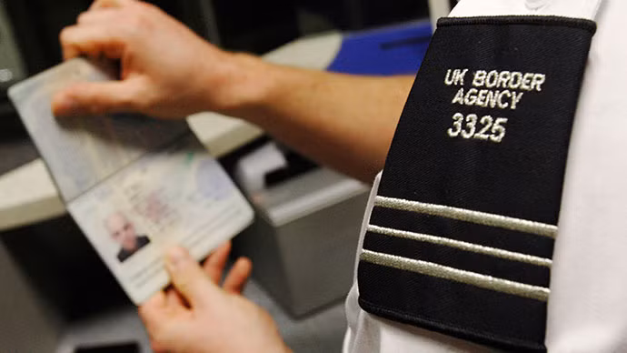 Nhân viên an ninh sân bay kiểm tra hộ chiếu một hành khách.