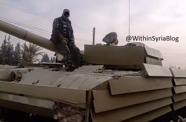 T-72 lắp thêm các tấm thép được đặt nghiêng để bảo vệ xe tăng. Nguồn ảnh: WithinSyriaBlog