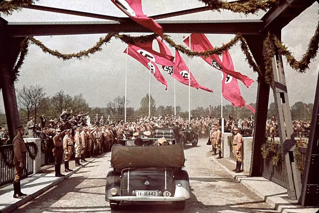 Người dân Đức đứng hai bên đường vẫy tay chào mừng các quan chức thuộc chính quyền Hitler tới dự lễ thành lập Fallersleben Volkswagen Works năm 1938.