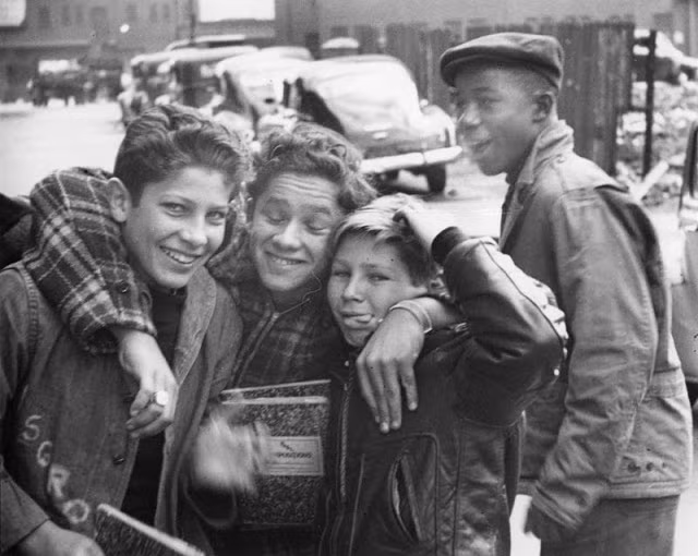 Một nhóm trẻ em nam thích thú và tạo dáng nghịch ngợm khi được chụp ảnh.