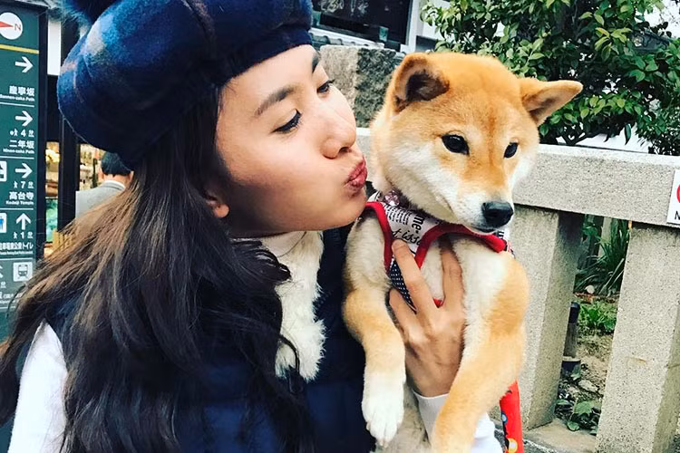 Khoảnh khắc nữ diễn viên phim “Cổng mặt trời” chu môi định hôn chú cún cưng trong chuyến du lịch Nhật Bản. Ảnh: FBNV