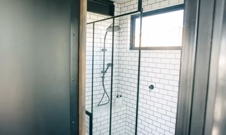 Phòng tắm nhỏ được trang bị vòi hoa sen và những vật dụng cần thiết.