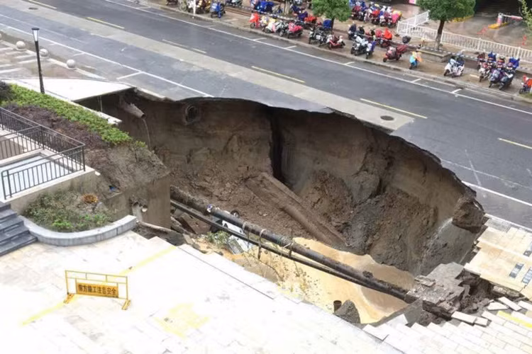 "Hố tử thần" nuốt trọn một chiếc xe tải ngày 10/6 tại thành phố Nam Thông, tỉnh Giang Tô, Trung Quốc. Hố được hình thành sau nhiều ngày mưa lớn. Theo các chuyên gia, những dư chấn động đất nhỏ hay trận mưa lớn cũng có thể khiến lớp đất đá đột ngột tan rã thành nhiều mảnh dưới lòng đất, gây nên sụt lún bất ngờ. Ảnh: Getty.