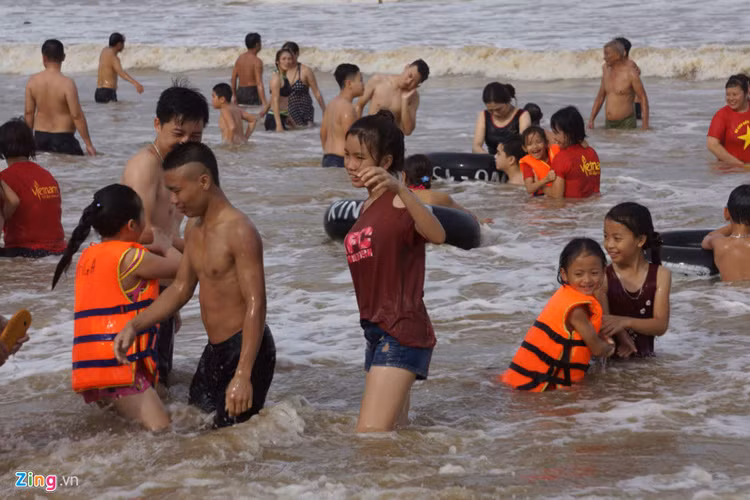 Trước những cơn sóng rất to, nhiều người lớn vẫn cho trẻ em ra biển nô đùa.