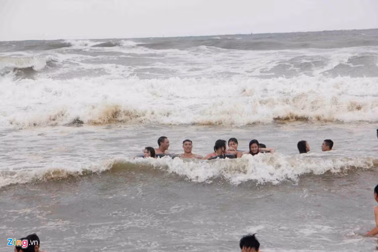 Thậm chí những nhóm thanh niên còn kéo nhau tắm xa bờ, để đón những ngọn sóng dữ.