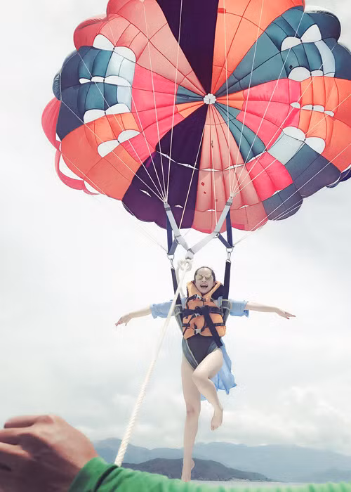 “Cá sấu chúa” Quỳnh Nga hào hứng chơi dù bay trong chuyến du lịch biển.