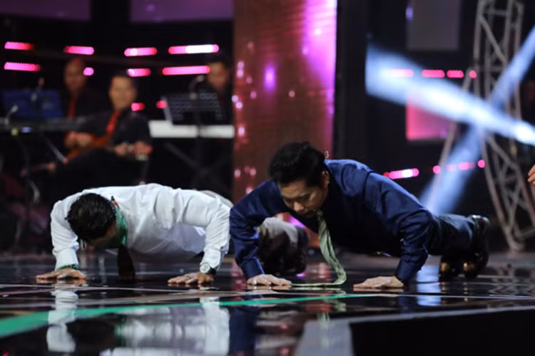 Ngoài Thần tượng Bolero, năm nay, Ngọc Sơn còn làm giám khảo cuộc thi âm nhạc Ai sẽ thành sao. Trong ảnh, anh hít đất cùng thí sinh khiến khán giả phấn khích. Ảnh: Zing