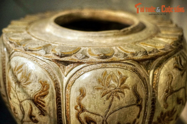 Miệng thống rộng, vai ngang chạm nổi băng cánh sen hai lớp cánh. Thân thống thuôn dần xuống đáy, chia thành 8 múi nổi. Trong mỗi múi khắc, tô nâu hình bình hoa sen trên nền men trắng ngà. Hoa sen được mô tả cách điệu theo chiều cắt dọc, các cặp cánh đối xứng.