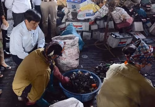 Tại một xưởng tái chế chì, hàng trăm chiếc ắc quy nằm la liệt, nền đất đen sì vì bột chì.