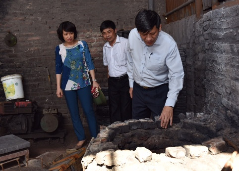 Thứ trưởng Bộ Y tế Nguyễn Thanh Long kiểm tra một lò nấu chì. Sau cuộc kiểm tra này, Bộ Y tế đã yêu cầu di dời ngay 13 hộ dân làm nghề tái chế chì còn lại ra khỏi thôn Đông Mai.