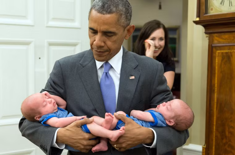 Tổng thống Barack Obama bồng trên tay hai em bé sinh đôi.