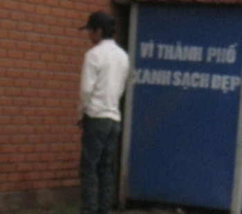 Nam thanh niên "tè" bậy ngay cạnh tấm bảng "Vì thành phố xanh sạch đẹp", thể hiện ý thức kém của một bộ phận người Việt.
