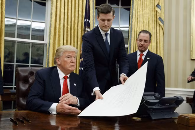 Rob Porter cầm tài liệu trình Tổng thống Trump trong một lễ ký hồi đầu năm. Ảnh: AP.