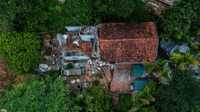 Nhìn từ trên cao, một phần của ngôi nhà ở vị trí gần mỏ đất sét bị sập hoàn toàn, kéo đổ cả bếp và công trình phụ. Phần sân phía trước cũng bị nứt toác. (Ảnh: Zing).