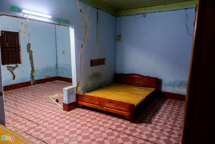 Toàn bộ phần sân và tường nhà bị nứt, trượt nghiêng về phía mỏ đất. (Ảnh: Zing).