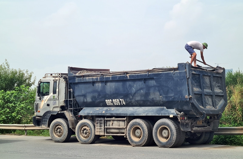 Tài xế này khi bị lực lượng chức năng dừng xe kiểm tra, thì vội vàng trèo lên thùng dùng xẻng san gạt, "cắt" ngọn cát đang chở.