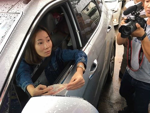 Nữ tài xế trả tiền lẻ ở trạm Cai Lậy. Ảnh Vietnamnet.