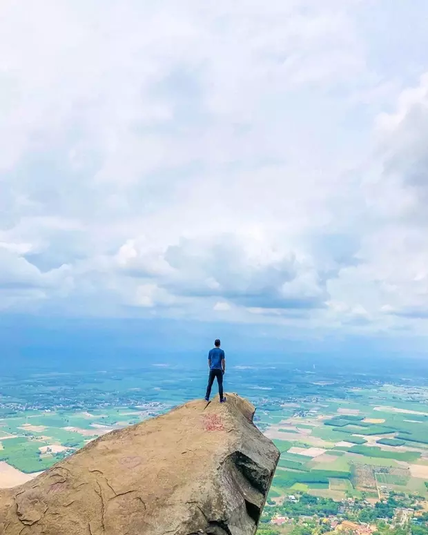 Nhìn từ xa, ngọn núi sừng sững như một chiếc nón úp giữa đồng bằng, nửa như muốn thách thức, nửa như muốn quyến rũ những đôi chân ưa khám phá.