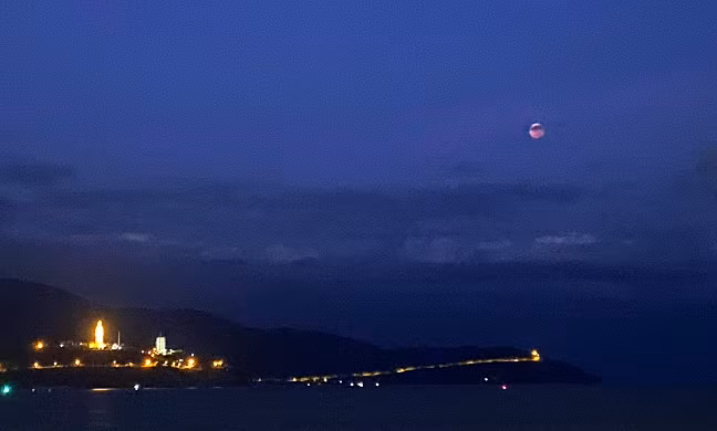 Quan sát từ bờ biển Mỹ Khê, mặt trăng mọc dần lên từ phía cuối đường chân trời. Thấp thoáng phía dưới là bán đảo Sơn Trà với tượng Phật bà Quân Âm được thắp sáng. (Nguồn: Dân trí)