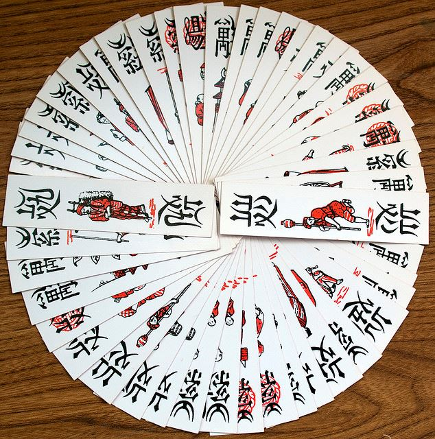 Lá bài làm bằng bìa cứng, hẹp và dài, một mặt để trơn, mặt kia có hình và chữ. Bề ngang lá bài khoảng chiều ngang hai ngón tay. Bề dọc dài hơn ngón tay giữa.