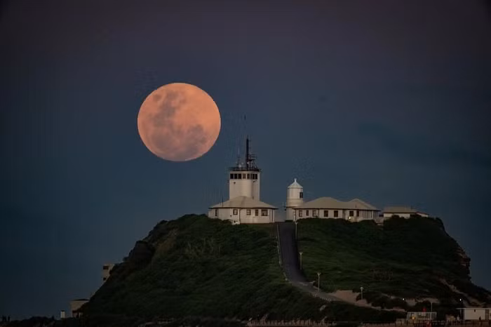 Hình ảnh Mặt trăng phía sau hải đăng Nobbys tại Australia. Mặt trăng màu đỏ phía sau một lò luyện thép tại Bethlehem, bang Pennsylvania (Mỹ). (Nguồn: shane.blue)