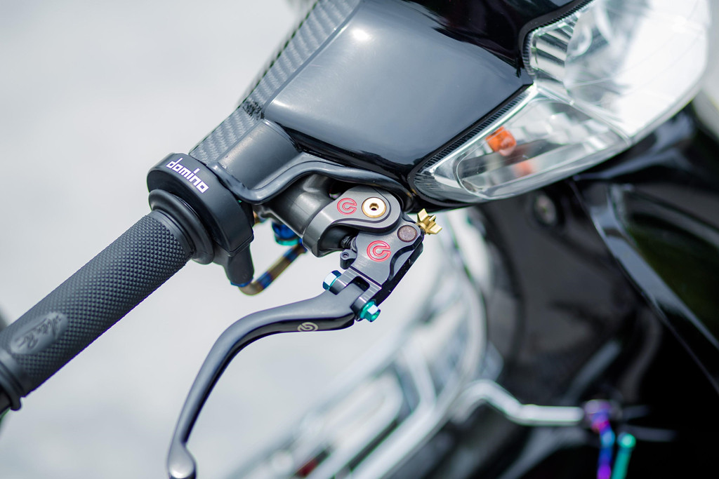 Chuyển qua khu vực ghi-đông, xe sở hữu tay phanh Brembo Rossi, bao tay Motion Pro. Cùm ga nguyên bản được thay bằng cùm ga của Domino, dây ga Kitaco và đầu ga bằng titanium.