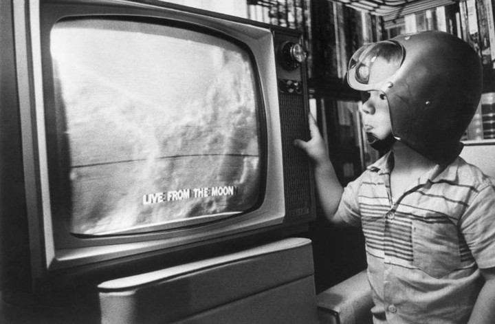Cậu bé Jay Bodnar chăm chú xem những hình ảnh đầu tiên của Mặt Trăng được phát sóng trên ti vi ngày 24/3/1965. Tàu thăm dò Ranger 9 đã giúp người Mỹ có những quan sát chưa từng thấy trước đó về bề mặt của Mặt Trăng và cậu bé Jay đã hào hứng đội chiếc mũ "phi hành gia" để kỷ niệm sự kiện này.