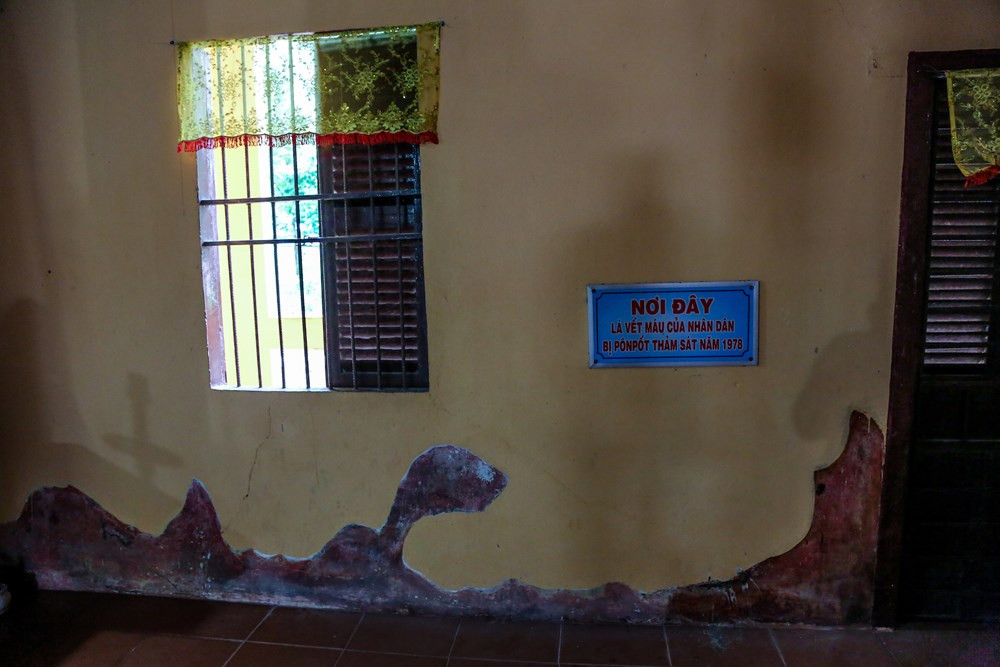 Bức tường dài đến hơn chục mét loang lổ những vết đỏ thẫm là những vết máu của đồng bào Ba Chúc trong cuộc thảm sát kinh hoàng khiến hơn 200 người dân thiệt mạng. Hơn 40 năm đã qua đi, nhưng dấu máu vẫn chưa thể phai mờ. (Ảnh: Minh Sơn/Vietnam+)