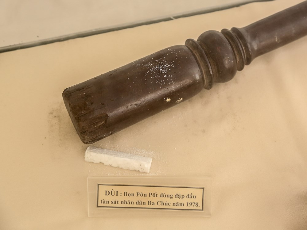 Trong ảnh là cây dùi gỗ mà Pol Pot dùng để đập vào đầu, tàn sát người dân Ba Chúc. Dấu vết của những cuộc hành hình năm xưa giờ vẫn còn vẹn nguyên ở những vết chày xước ăn sâu vào đầu chiếc dùi đen đúa ấy. (Ảnh: Minh Sơn/Vietnam+)