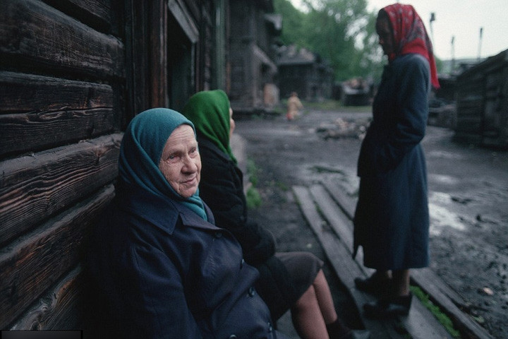 Phụ nữ Siberia ngồi trước nhà trong không khí ảm đạm.