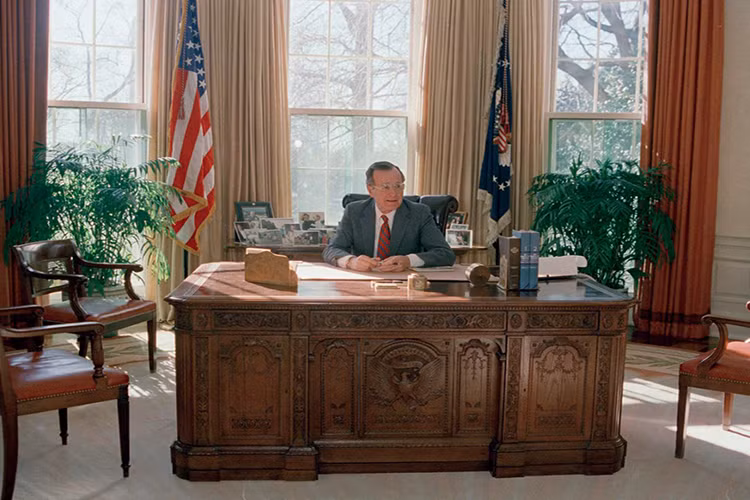 Chiếc bàn Kiên Định của cựu Tổng thống George HW Bush trông khá gọn gàng, khi ông giữ những bức ảnh cá nhân của mình ở chiếc bàn phía sau lưng, còn trên bàn làm việc cũng không đặt quá nhiều vật dụng. Ảnh: Business Insider.