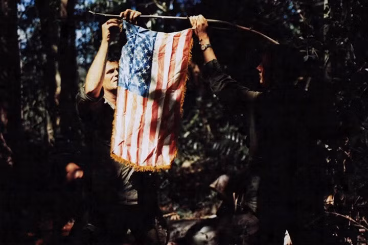Quân nhân Mỹ thuộc sư đoàn bộ binh số 4 cố treo cờ Mỹ trên đồi số 927 ở chiến trường Đắc Tô, Kon Tum, miền Nam Việt Nam vào đầu tháng 12/1967. Ảnh: Bộ Quốc phòng Mỹ.