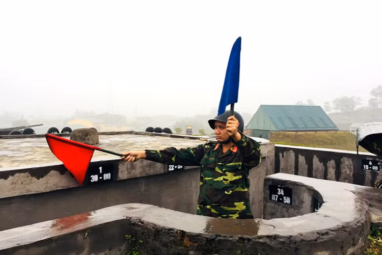 Chỉ huy Đại đội 1 lệnh cho các khẩu đội quan sát, bắt mục tiêu bằng khẩu lệnh kết hợp với cờ chỉ huy.