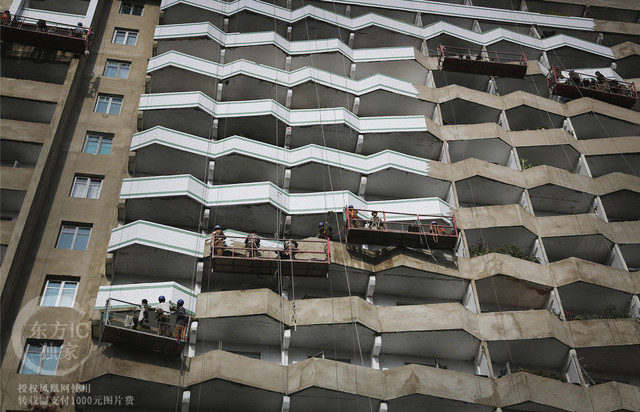 Các công nhân đang sơn lại các bức tường mặt ngoài của một chung cư ở Bình Nhưỡng.