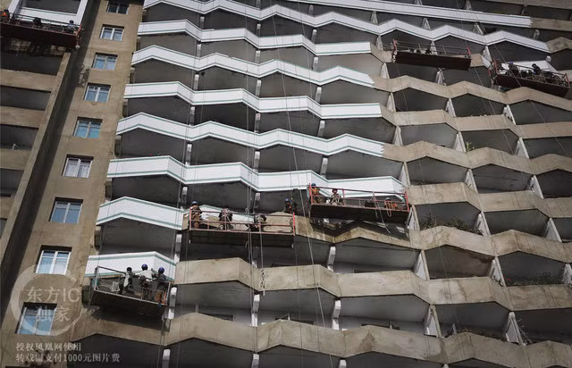 Các công nhân đang sơn lại các bức tường mặt ngoài của một chung cư ở Bình Nhưỡng.