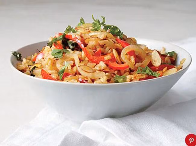 Cơm chiên với hạt điều và hạnh nhân: Xắt hạnh nhân và hành tây để nấu cho nhanh và đẹp hơn. Bạn có thể thay hạt điều cho hạnh nhân. Món ăn thơm và rất bùi, mềm.