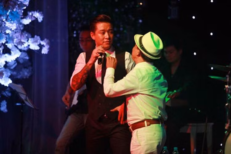 Đang tập trung hát theo yêu cầu của khán giả tại một đêm nhạc, Tuấn Hưng bị một khán giả đòi mic để song ca. Sau một hồi bối rối, nam ca sĩ chấp nhận để fan biểu diễn cùng mình. Ảnh: Vietnamnet