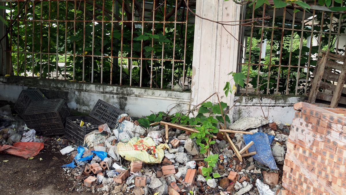 Phần tường rào của chợ sau thời gian dài cũng hư hỏng, một vài nơi trở thành nơi đổ rác của người dân. (Ảnh: Tiền Phong).