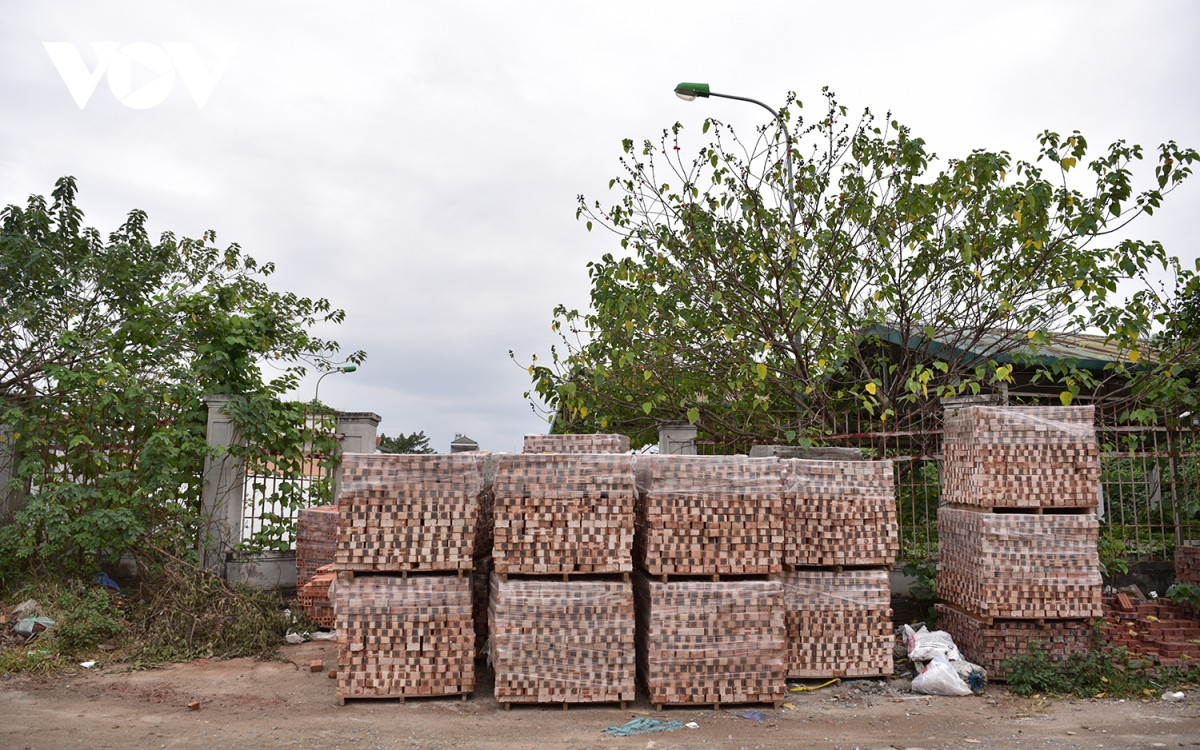 Vật liệu xây dựng được tập kết chắn cả lối đi vào cổng chính của chợ. (Ảnh: VOV).