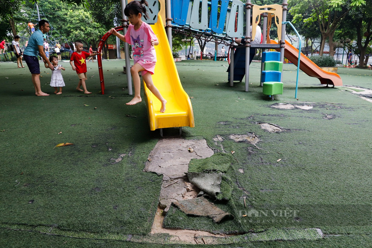 Do phần thảm cỏ bị rách nát nên trẻ em phải nhảy ra khỏi cầu trượt khi vui chơi. (Ảnh: Dân Việt).