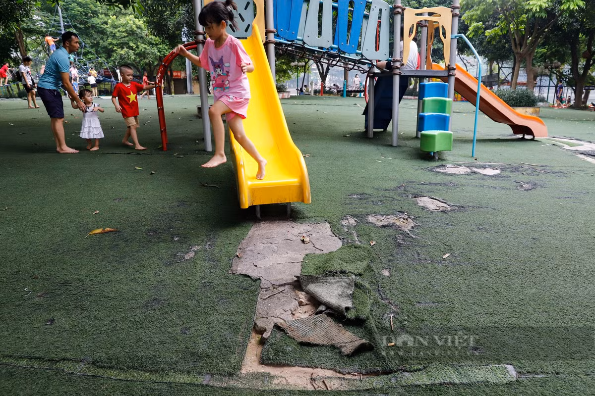Do phần thảm cỏ bị rách nát nên trẻ em phải nhảy ra khỏi cầu trượt khi vui chơi. (Ảnh: Dân Việt).