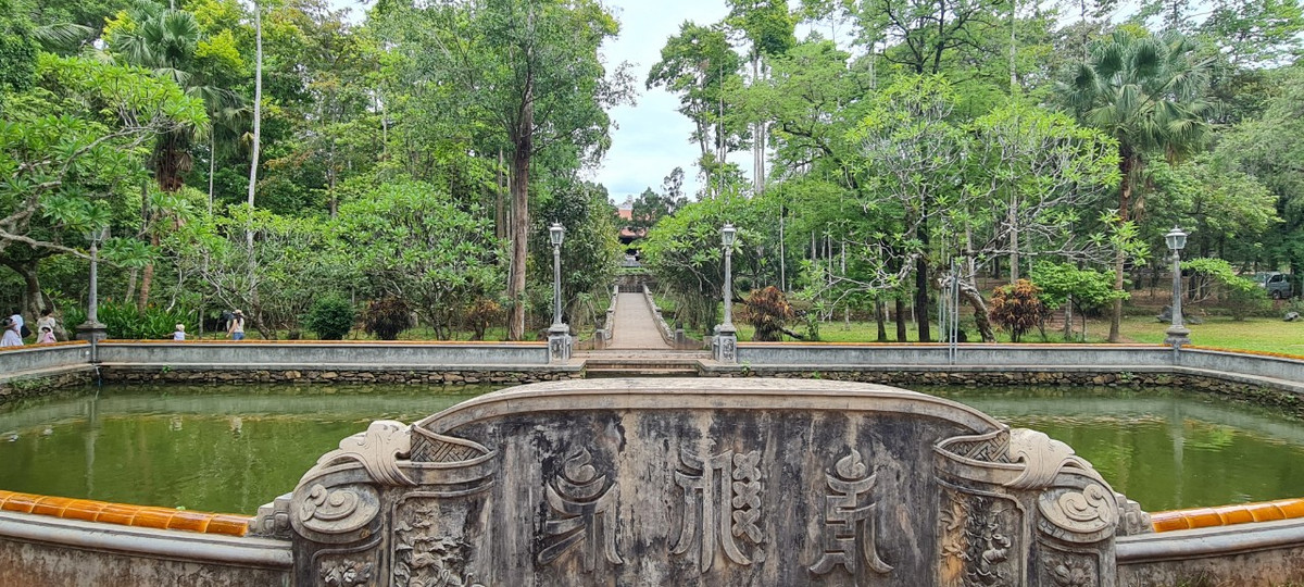 Hồ bán nguyệt ngay trung tâm cổng tam quan với đàn cá trê đến cả trăm con. Mặt hồ xanh thẳm, soi bóng tà dương.