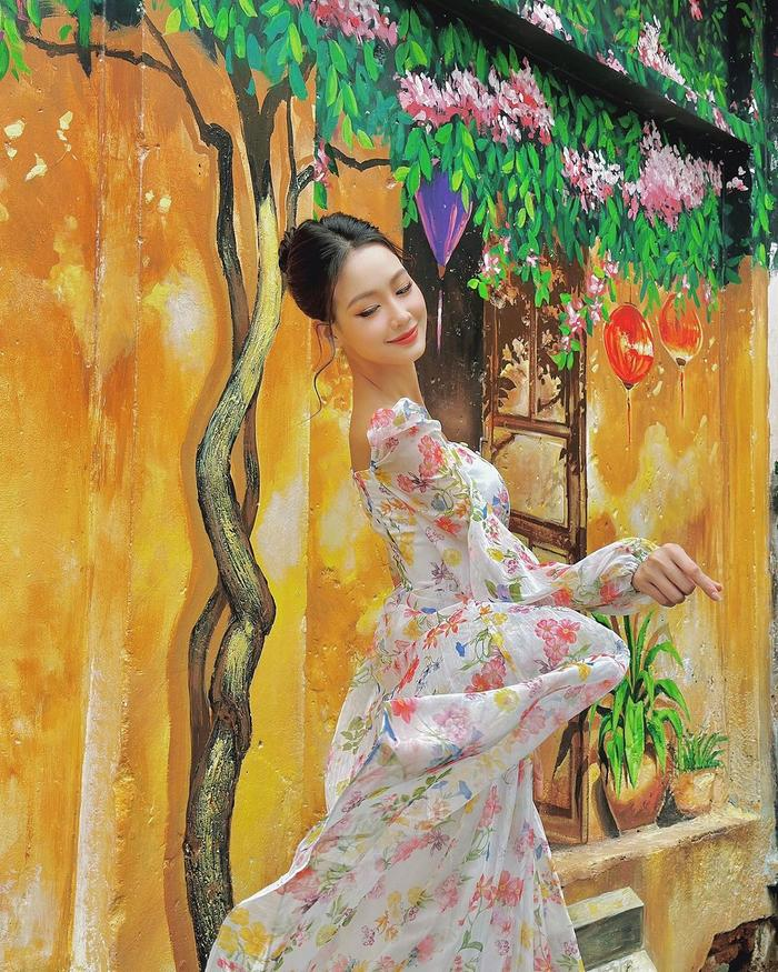 Mỹ nhân 22 tuổi khoác trên người chiếc váy phủ kín họa tiết hoa sặc sỡ. Thiết kế cổ vuông vừa kín đáo, vừa giúp cô khoe được xương quai xanh mảnh khảnh.