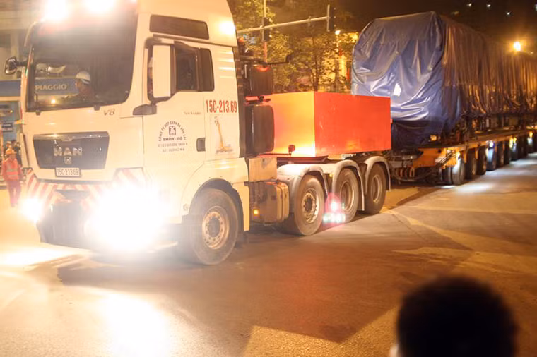 Đến 1h15 ngày 21/2, những chiếc xe siêu trường siêu trọng bắt đầu chở các đầu tàu vào khu vực ga La Khê để chuẩn bị ghép nối lên đường ray trên cao.