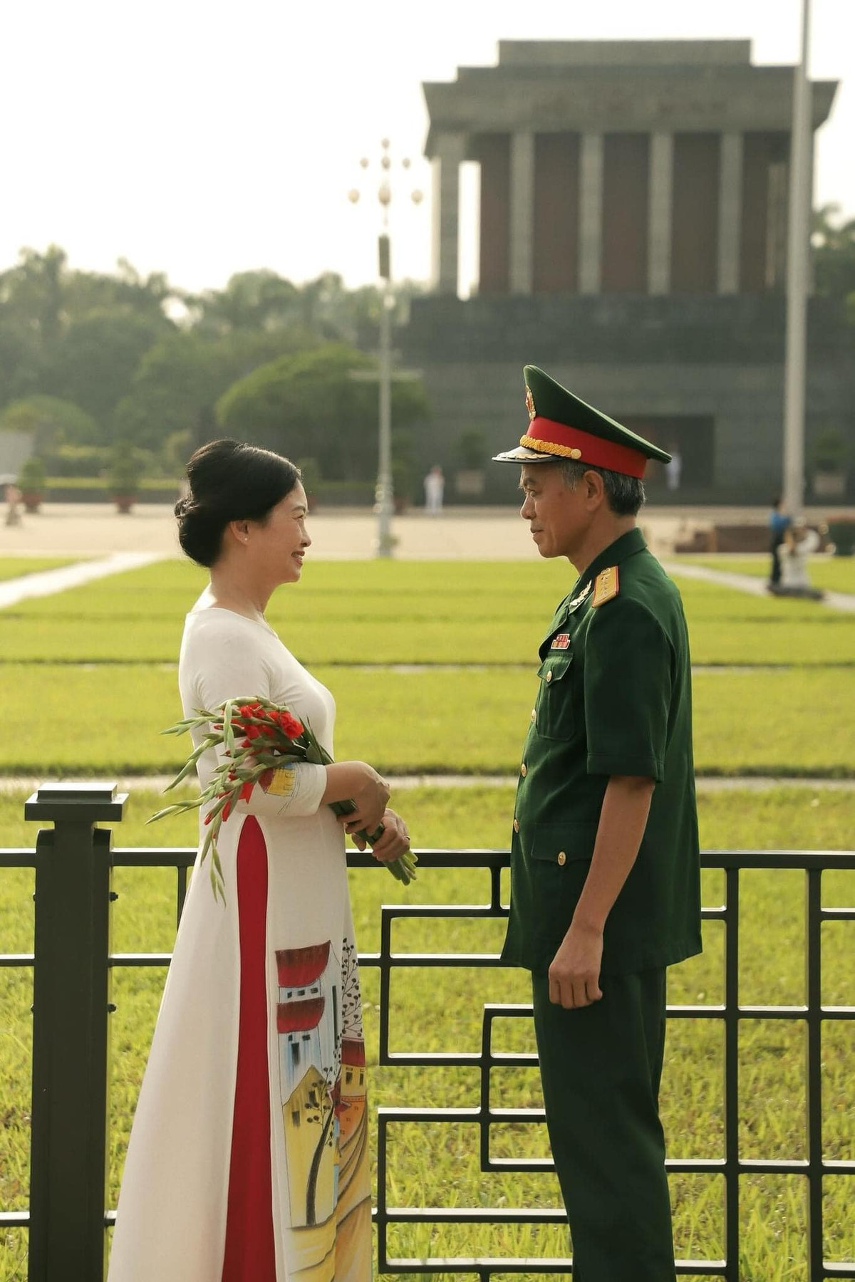 Cụ bà diện áo dài trắng, duyên dáng mà đằm thắm, thể hiện hình ảnh người hậu phương vững chắc cho chồng.