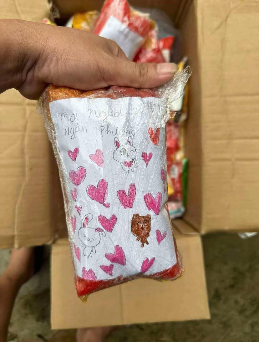 Theo đó, trên những chiếc bánh mì được đóng gói, nhiều em học sinh đã gói kèm tờ giấy được xé vội, hoặc tờ giấy note những dòng động viên đầy xúc động, để gửi đến đồng bào vùng lũ.