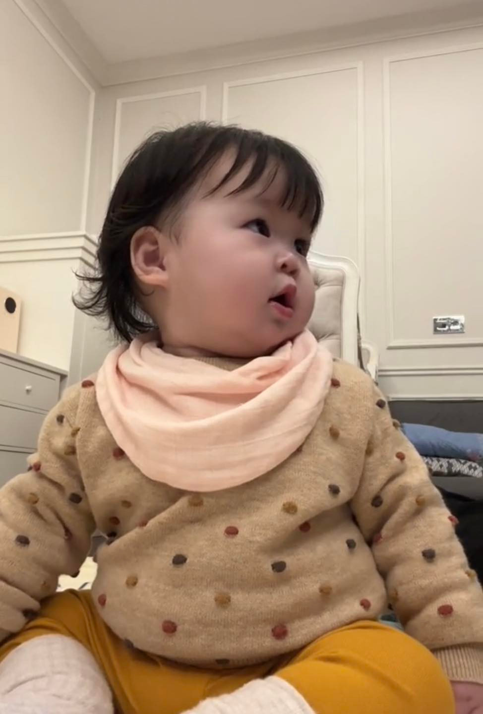 Điều đặc biệt, em bé nhà Hoa hậu không hề khóc lói, đòi mẹ và chỉ "nuối tiếc" ngoái nhìn theo chút xíu, sau đó tập trung nhìn vào màn hình, nở nụ cười tươi đáng yêu.