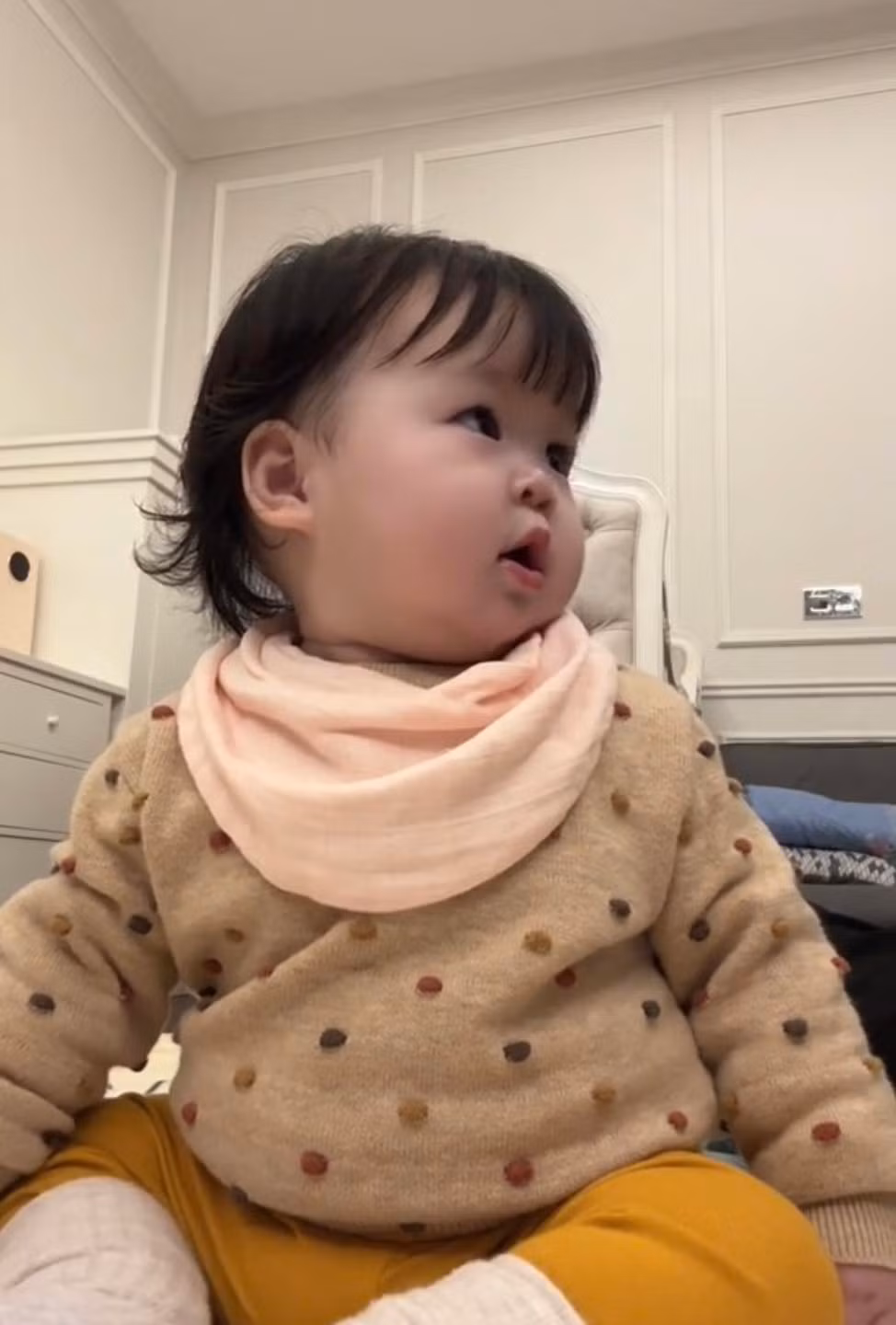 Điều đặc biệt, em bé nhà Hoa hậu không hề khóc lói, đòi mẹ và chỉ "nuối tiếc" ngoái nhìn theo chút xíu, sau đó tập trung nhìn vào màn hình, nở nụ cười tươi đáng yêu.