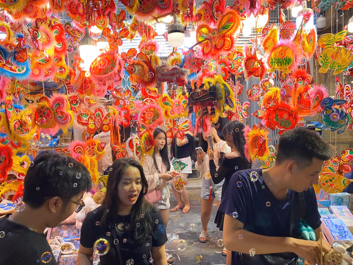 Nhiều bạn nữ đã xúng xính váy áo, mua 1 vài món đồ chơi nhỏ xinh để được chụp ảnh. Trong những hàng quán được treo nhiều đèn đủ màu và hình thù, rất đông người đứng xếp hàng chờ đến lượt để chụp hình.